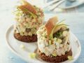 Forellen-Tatar mit Gurke und Lauchzwiebeln auf Pumpernickel Rezept
