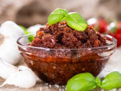 Pesto Rosso in einer Glasschale mit Basilikum