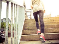 Gut trainierte Frau springt eine Treppe hinauf 