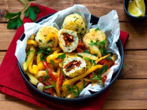 Paella-Reis-Bällchen gefüllt mit Tomaten auf mediterranem Gemüse Rezept