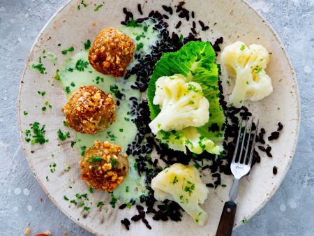 Haselnussbällchen mit schwarzem Reis, Blumenkohl und Kräutersauce