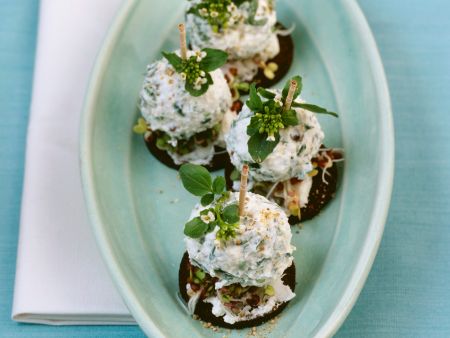 Ricotta-Brunnenkresse-Bällchen auf Sprossen und Pumpernickel