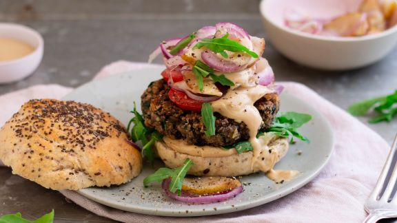 Burger mit Zwiebeln und Birne und nebenliegendem Deckel