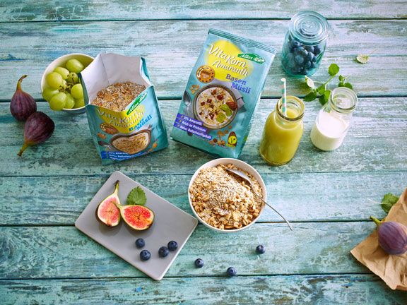 Tisch mit Allos Müslis, Obst und einer Schale 