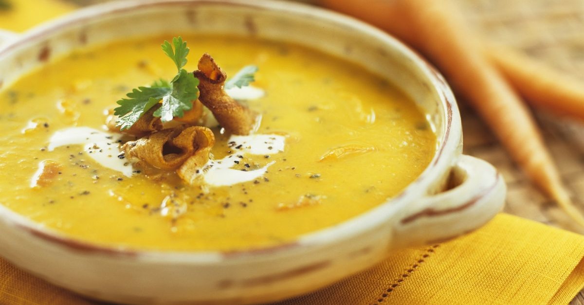 Foto von cremiger Karottensuppe auf schwarzem Teller