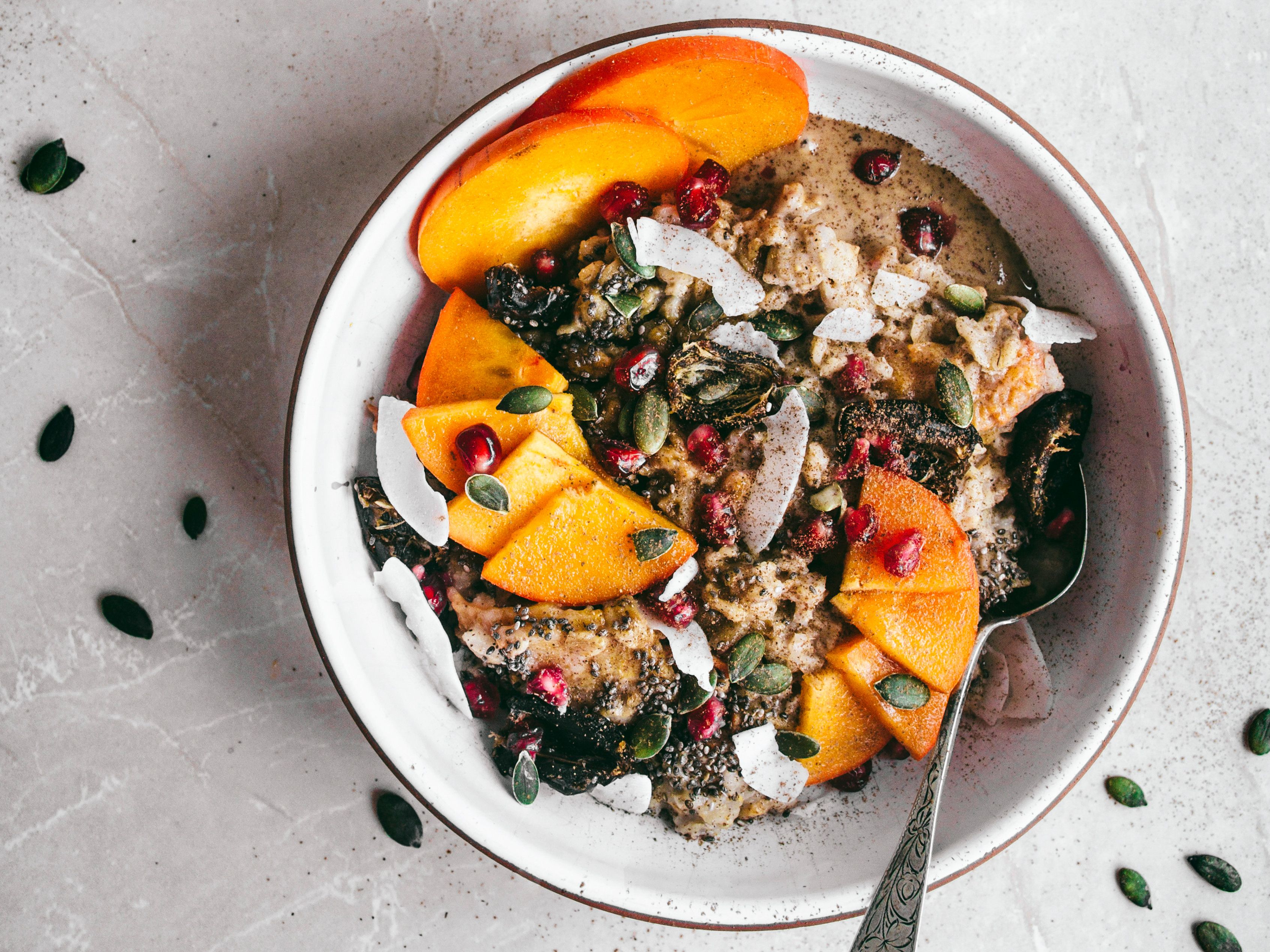 Porridge mit Kokosnuss, Kaki und Granatapfel Rezept | EAT SMARTER